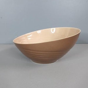 May include: A brown ceramic bowl with a slightly curved rim and a rippled design.