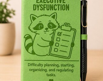 May include: A lime green notebook featuring a cartoon raccoon holding a clipboard with a checklist. The text reads "EXECUTIVE DYSFUNCTION" and "Difficulty planning, starting, organizing, and regulating tasks." A black pen is held by a green elastic loop.