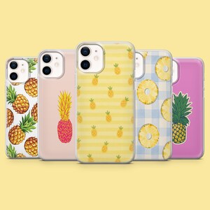 May include: Five smartphone cases arranged in a row. The first features a pineapple pattern on a clear background. The second is a light pink case with a single pineapple. The third has yellow stripes with small pineapples. The fourth shows pineapple slices on a blue gingham pattern. The fifth is a solid pink case with a single pineapple illustration.