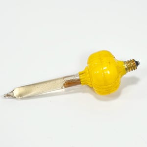 May include: A yellow decorative light bulb featuring a rounded, ribbed upper section and a long, clear, tapered glass stem. The bulb includes a metallic screw-in base at the top, designed for insertion into a socket, with a pointed tip at the bottom.