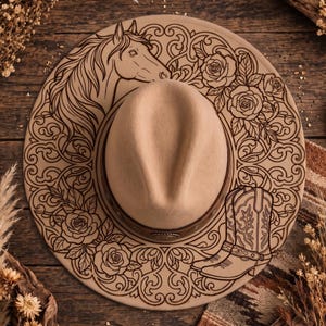 May include: A beige felt hat featuring a dark brown leather band with metallic accents. The wide brim is decorated with intricate dark brown line art illustrations of a horse head, blooming roses, and a pair of western-style cowboy boots.