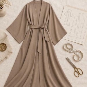 Puede incluir: Un kimono abaya color topo con mangas anchas y un cinturón de lazo a juego. La imagen incluye el texto Kimono Abaya, Patron de couture PDF, Tailles S à XL y Médine Paris, junto a un boceto de patrón, una cinta métrica y unas tijeras.