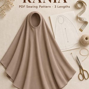 May include: A taupe-colored khimar with a rounded face opening, accompanied by a paper sewing pattern, a measuring tape, a ball of twine, and metal scissors. The text reads: Khimar RANIA, PDF Sewing Pattern, 3 Lengths, and Médine Paris.