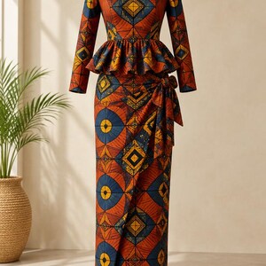 May include: A long-sleeved floor-length dress featuring a vibrant geometric pattern in shades of burnt orange, deep blue, and yellow. The garment includes a peplum waist detail and a wrap-style skirt with a side tie accent at the hip.