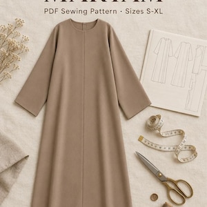 May include: A PDF sewing pattern for an Abaya Maryam in sizes S-XL, featuring a solid taupe long-sleeved dress with a round neckline, accompanied by a technical sketch, a measuring tape, metal scissors, a single button, and a spool of thread.