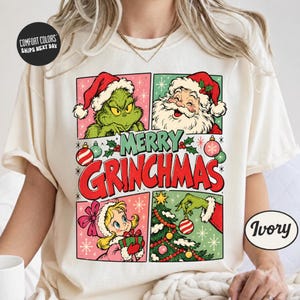 Könnte beinhalten: Ein elfenbeinfarbenes T-Shirt mit einem Grafikdruck aus vier Feldern, die eine grüne Figur mit Weihnachtsmütze, den Weihnachtsmann, ein blondes Kind mit Geschenk und eine grüne Hand beim Schmücken eines Baumes zeigen, mit rotem Text MERRY GRINCHMAS.