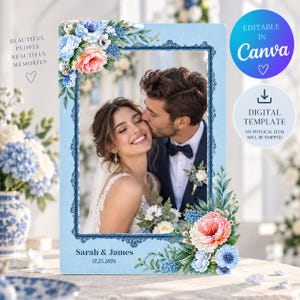 Op de afbeelding: Een rechthoekige lichtblauwe trouwfotolijst met een donkerblauwe sierrand, versierd met aquarelachtige roze en blauwe bloemstukken in de linker bovenhoek en rechter onderhoek, met de tekst Sarah & James 11.25.2026.