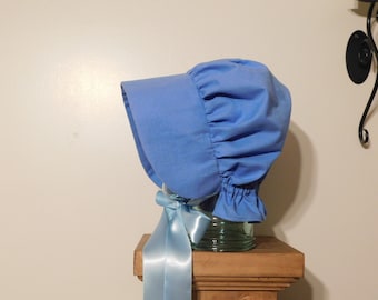 May include: A light blue bonnet with a gathered ruffle and a matching light blue satin ribbon.