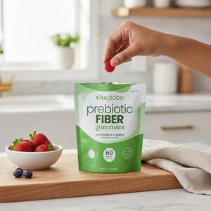 May include: A white and green pouch of Vitaglobe prebiotic fiber gummies with text reading 60 gummies per bag, mixed berry, and gluten free. A red gummy is held above the pouch, and a white bowl of fresh strawberries and blueberries sits nearby.