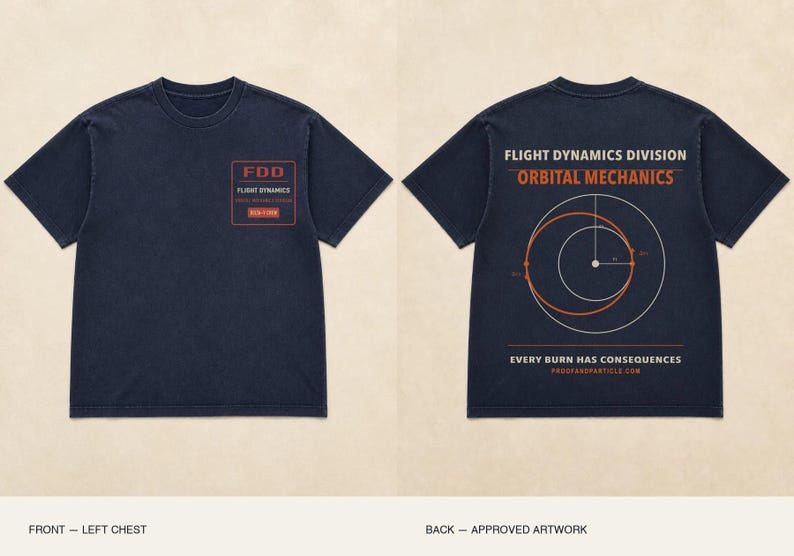 Op de afbeelding: Een donker marineblauw t-shirt met korte mouwen. Op de linkerborst staat een rood rechthoekig grafisch ontwerp met de tekst FDD FLIGHT DYNAMICS. De achterkant toont een grote afbeelding met de tekst FLIGHT DYNAMICS DIVISION ORBITAL MECHANICS, een circulair orbitaal diagram en de tekst EVERY BURN HAS CONSEQUENCES PROOFANDPARTICLE.COM.