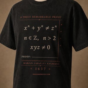 May include: A black short-sleeve t-shirt featuring a mathematical graphic in red and white. The text reads A TRULY REMARKABLE PROOF, x^n + y^n ≠ z^n, n ∈ ℤ, n > 2, xyz ≠ 0, PROOF: MARGIN CAPACITY EXCEEDED, 1637, and PROOFANDPARTICLE.COM.