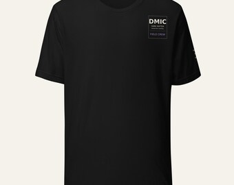 Puede incluir: Una camiseta negra de manga corta con un gráfico rectangular blanco en el pecho izquierdo. El gráfico contiene el texto DMIC, DARK MATTER INVENTORY CONTROL y FIELD CREW. La camiseta tiene cuello redondo y un dobladillo recto estándar.