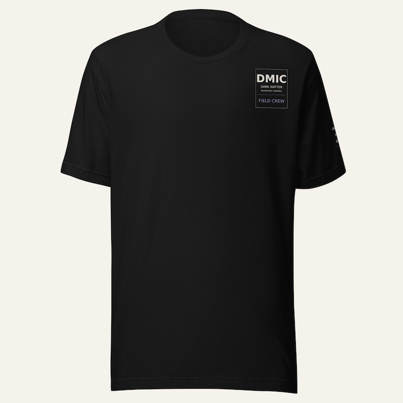 May include: A black short-sleeve t-shirt featuring a white rectangular graphic on the left chest. The graphic contains the text DMIC, DARK MATTER INVENTORY CONTROL, and FIELD CREW. The shirt has a crew neckline and a standard straight hem.