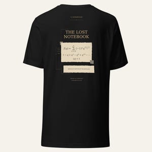May include: A black short-sleeved t-shirt featuring a graphic on the back. The design includes the text THE LOST NOTEBOOK, a mathematical summation formula, and the phrase RESULTS WITHOUT ROADMAPS printed on beige paper-like rectangular shapes.