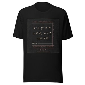 May include: A black short-sleeved t-shirt featuring a square graphic with the text A TRULY REMARKABLE PROOF, mathematical equations including x^n + y^n &ne; z^n, n &isin; ℤ, n > 2, xyz &ne; 0, the word PROOF, MARGIN CAPACITY EXCEEDED, and the year 1637.