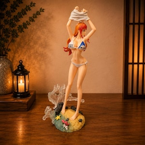 May include: A standing anime-style figurine of a character with long orange hair, wearing a white bikini top with the word "SEXY" printed on it and matching white bikini bottoms. The figure is posed on a sandy base with small starfish and coral.
