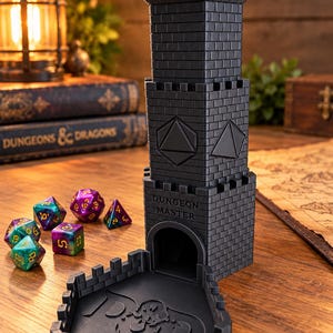 May include: A black plastic dice tower shaped like a castle turret with a crenelated top and a base tray. The tower features the text Dungeon Master above the arched opening and embossed polyhedral dice shapes on the sides.