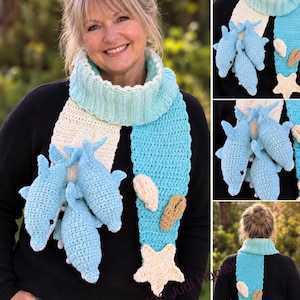 Op de afbeelding: Een gehaakte sjaal met een geribbeld lichtblauw nekgedeelte, met één kant in crème en de andere in felblauw. De sjaal is versierd met drie lichtblauwe gehaakte dolfijnen, twee beige gehaakte schelpen en een crèmekleurige gehaakte zeester.