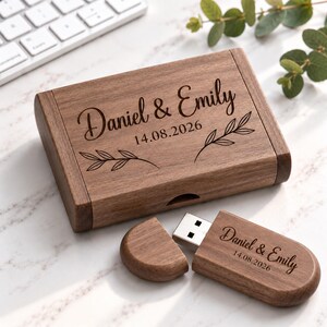May include: A rectangular dark brown wooden box and a matching wooden USB flash drive. Both items are engraved with the text Daniel & Emily and the date 14.08.2026. The box lid features a decorative leaf design on either side of the text.