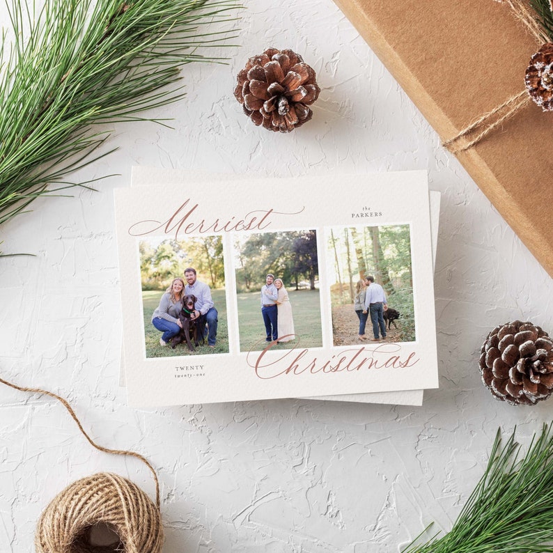 May include: A Christmas card featuring a red cursive font that reads "Merriest Christmas" and three photographs of a couple and their dog in a woodland setting. The text "The Parkers" and "Twenty Twenty-One" are also included on the card.