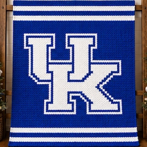 May include: A rectangular crochet blanket featuring a royal blue background with a large white UK logo in the center. The design includes horizontal white stripes at the top and bottom edges, creating a bold, high-contrast athletic aesthetic.