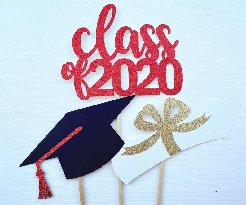 May include: Red glitter "Class of 2020" cake topper with a graduation cap and diploma. The graduation cap is black with a red tassel. The diploma is white with a gold glitter bow. Perfect for a graduation celebration.