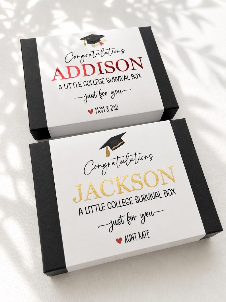 Op de afbeelding: Twee rechthoekige zwarte geschenkdozen met witte hoezen. De bovenste hoes leest Congratulations ADDISON A LITTLE COLLEGE SURVIVAL BOX just for you MOM & DAD. De onderste hoes leest Congratulations JACKSON A LITTLE COLLEGE SURVIVAL BOX just for you AUNT KATE.