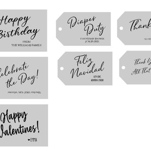 May include: Seven rectangular light gray gift tags with rounded corners and a circular hole on the left side. Each tag features black printed text in various fonts, including phrases like Happy Birthday, Diaper Duty, Thank you, Celebrate the Day, Feliz Navidad, Thank You for All That You Do, and Happy Valentines.