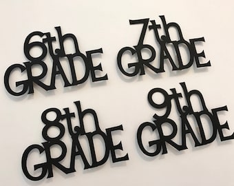 Könnte beinhalten: Vier schwarze Papierschnitte mit den Worten "6th Grade", "7th Grade", "8th Grade" und "9th Grade" in einer stilisierten Schriftart.