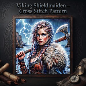 May include: A framed cross stitch pattern titled Viking Shieldmaiden - Cross Stitch Pattern, featuring an illustration of a person with braided hair, a fur mantle, and an axe, set against a stormy coastal background with lightning.
