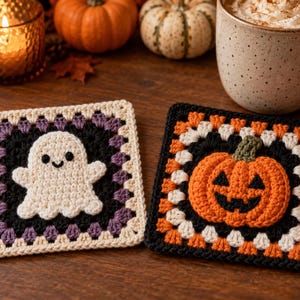 May include: Two square crochet coasters featuring Halloween motifs. One coaster displays a white ghost with black eyes and a smile on a black and purple background. The other coaster features an orange jack-o'-lantern with a green stem on a black and orange background.