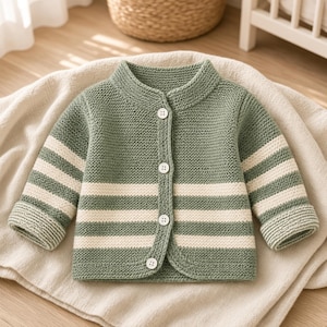 Könnte beinhalten: Eine salbeigrüne Strickjacke mit Rundhalsausschnitt, langen Ärmeln mit cremefarbenen Querstreifen und einer Knopfleiste auf der Vorderseite mit vier weißen, runden Knöpfen. Das Kleidungsstück ist in einer strukturierten Kraus-Rechts-Strickart gefertigt.