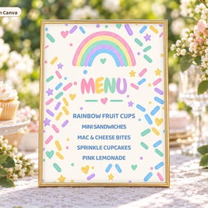 May include: A rectangular gold-framed sign featuring a pastel rainbow graphic, colorful sprinkles, and the text MENU followed by RAINBOW FRUIT CUPS, MINI SANDWICHES, MAC & CHEESE BITES, SPRINKLE CUPCAKES, and PINK LEMONADE on a white background.