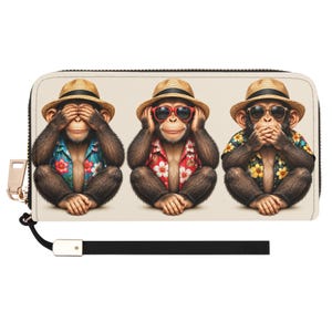 Puede incluir: Una cartera rectangular con cremallera que presenta un estampado gráfico de tres monos con sombreros de paja y camisas florales. El primer mono se cubre los ojos, el segundo lleva gafas de sol rojas y el tercero se cubre la boca. Incluye correa.
