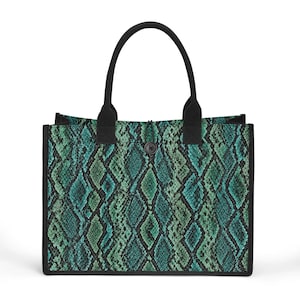 Peut inclure: Un sac fourre-tout rectangulaire arborant un motif peau de serpent dans des tons bleu sarcelle et vert foncé. Le sac est doté de anses en tissu noir uni et d'un liseré noir sur les bords. Un bouton noir unique ferme le haut du sac.