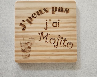 May include: A square light-colored wooden coaster featuring a laser-engraved design. The text reads J'peux pas j'ai Mojito, accompanied by a detailed line-art illustration of a glass containing a Mojito cocktail with a lime slice garnish.