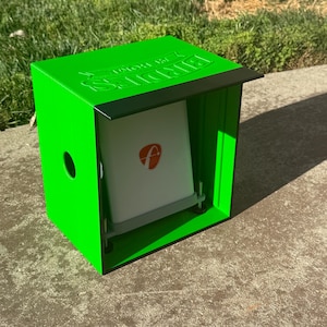 May include: A bright green metal box with a black top edge and the embossed text "BIRDIES" on the top surface. Inside the box is a white square panel featuring a red circular logo with a white letter "f" and a gray base with two metal posts.