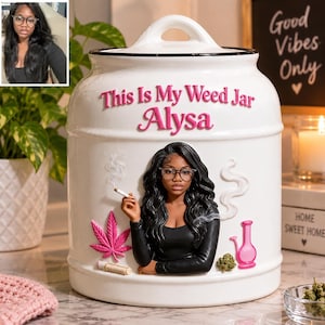 Könnte beinhalten: Ein weißes Keramik-Vorratsglas mit Deckel, das den rosa Schriftzug "This Is My Weed Jar Alysa" trägt. Das Glas zeigt eine erhabene Illustration einer Person mit langem schwarzem Haar und Brille, ein rosa Cannabisblatt, eine rosa Bong und Rauch.