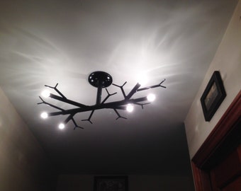 Unique hanging branch ceiling lamp, uses TEN  20 Watt halogen bulbs. A beautiful rustic addition to almost any space