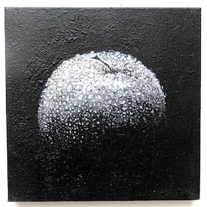 Op de afbeelding: Een vierkant schilderij op canvas met een witte appel bedekt met talloze waterdruppels tegen een effen zwarte, getextureerde achtergrond. De appel is weergegeven in tinten wit en grijs, wat het vocht op het oppervlak benadrukt.