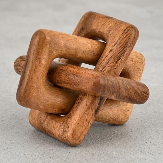 A hand-carved wooden chain where every interlocking link was sculpted from a single piece of wood — the kind of object people pick up and refuse to believe isn't assembled from separate parts.