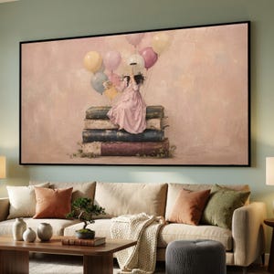 May include: A rectangular wall art print featuring a person in a light pink dress sitting on a stack of large, weathered books. The person holds an open book in front of their face, surrounded by a cluster of floating pastel-colored balloons.