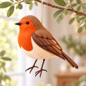 Può includere: Un ornamento in feltro a forma di pettirosso con petto arancione brillante, testa e ali marroni e ventre color crema. L'uccellino ha un piccolo becco nero, un occhio nero e sottili zampe marrone scuro. È dotato di un cordino per essere appeso.