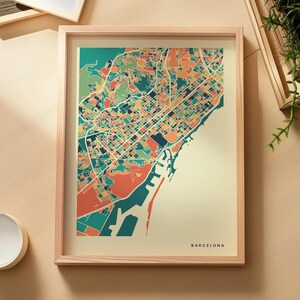 以下が含まれることがあります： バルセロナの地図が額装されたプリント。クリーム色の背景に、ティール、オレンジ、イエロー、ダークブルーの色合いで描かれた幾何学的な街路図が特徴です。右下隅には「BARCELONA」という文字が小さな黒い大文字で印刷されています。