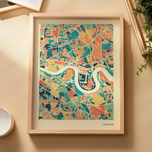 Könnte beinhalten: Ein gerahmter Kunstdruck einer Stadtkarte von London mit einem stilisierten, farbenfrohen Straßennetz in Blaugrün, Orange, Gelb und Dunkelblau. Die Karte zeigt die geschwungene Themse in Creme, mit dem Wort LONDON in der unteren rechten Ecke.