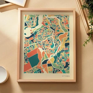 Peut inclure: Une impression cartographique encadrée d'Ottawa présentant une grille abstraite et colorée de rues et de cours d'eau dans des tons de bleu sarcelle, orange, jaune et bleu foncé. L'impression est dans un cadre en bois clair avec OTTAWA en bas.