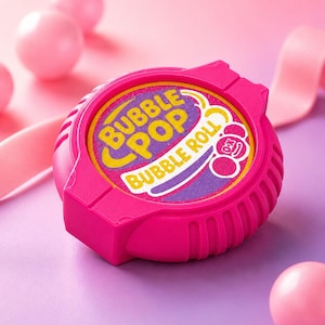 May include: A round, bright pink plastic container for Bubble Pop Bubble Roll gum. The center label features yellow text reading Bubble Pop and white text reading Bubble Roll against a purple and yellow background with small pink circle graphics.