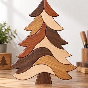 May include: A decorative wooden tree sculpture composed of interlocking, curved segments in various natural wood tones, including light maple, medium oak, and dark walnut. The piece features a pointed top and a wide base, standing upright on a flat surface.