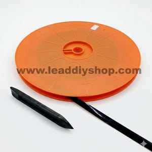 May include: A bright orange circular plastic spool featuring the text www.leaddiyshop.com printed in dark letters across the center. A long, thin black strip extends from the spool, accompanied by a separate, pointed black plastic tool.