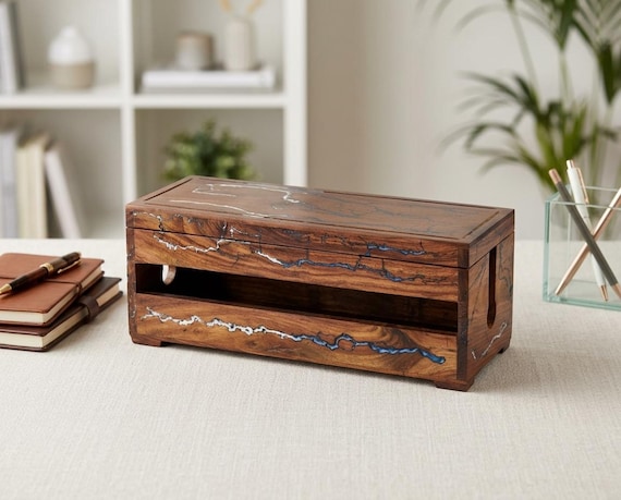 A handcrafted wooden cable management box with a fractal resin inlay — so it actually looks like a piece of desk art rather than a glorified wire-hider.